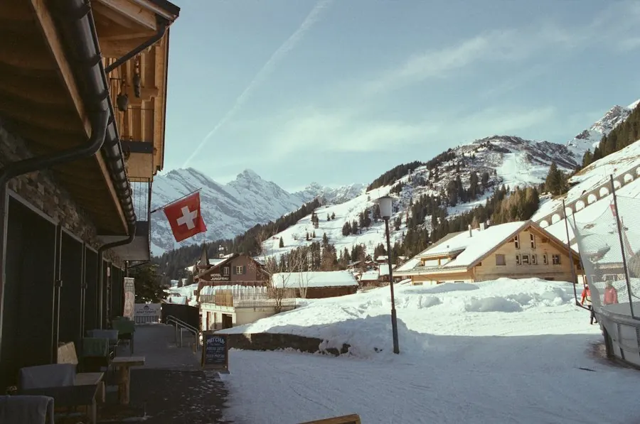 Village de montagne suisse enneigé avec un drapeau suisse